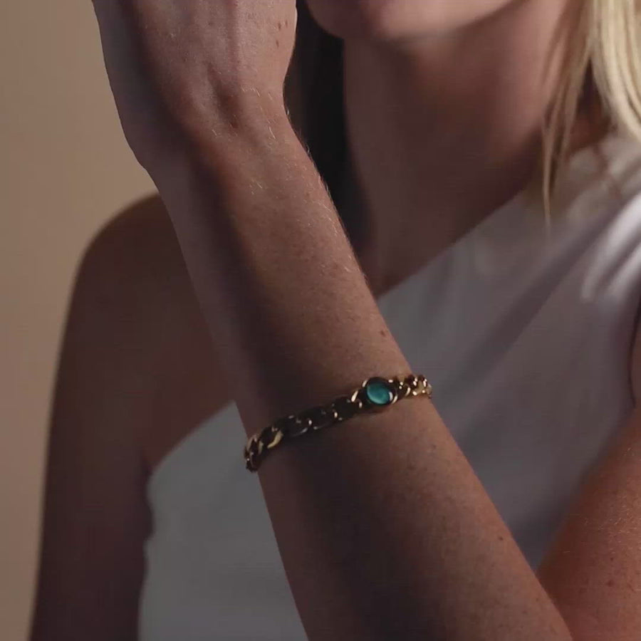 Video of woman wearing glow in the dark gold plated moon phase link bracelet