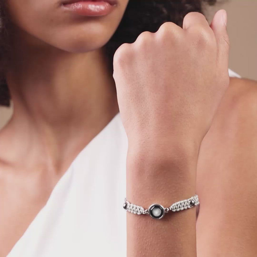 Video of woman wearing silver plated adjustable moon phase bracelet in sky gray 