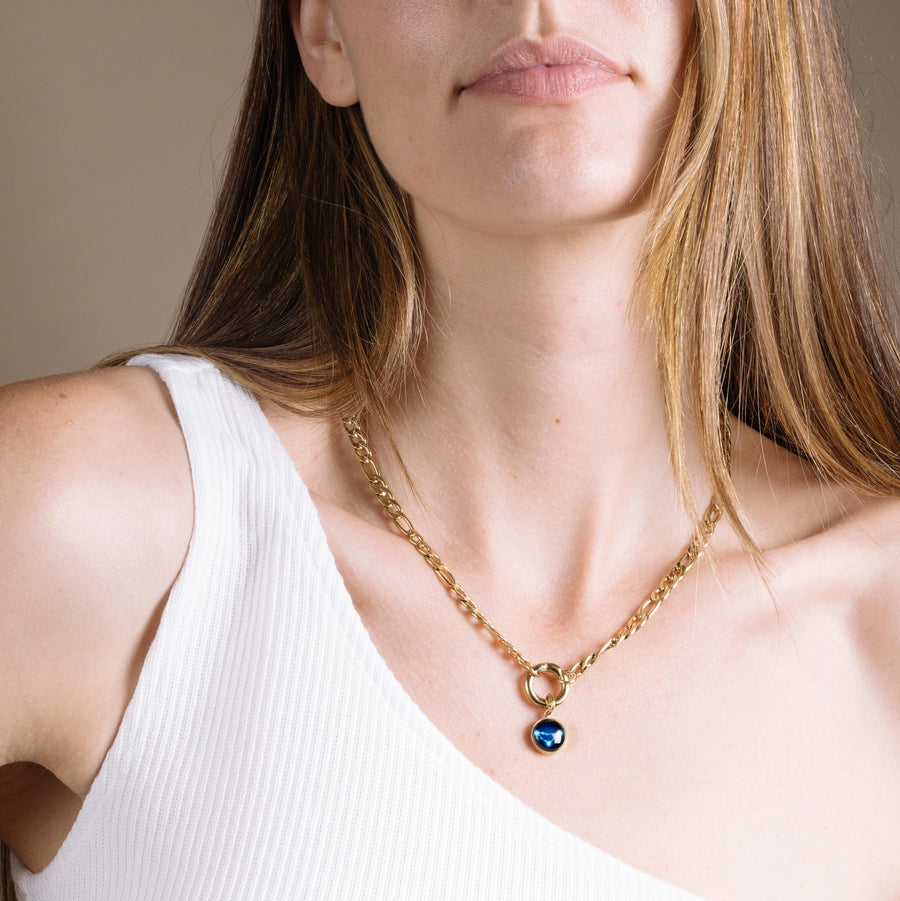 Woman wearing gold plated curb chain necklace with constellation astrology pendant