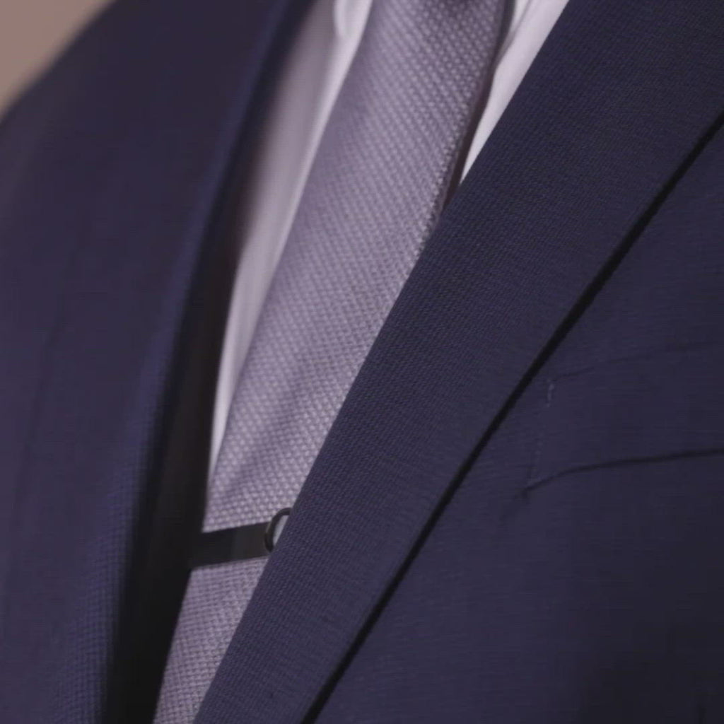 Video of man wearing moon phase tie bar in matte black stainless steel