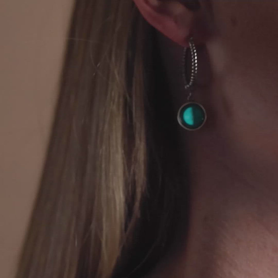 Video of woman wearing The Carina Hoops in Stainless Steel in the dark. Glow in the dark.