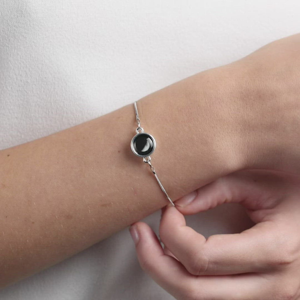 Video of woman wearing silver plated pendant with adjustable stainless steel bracelet