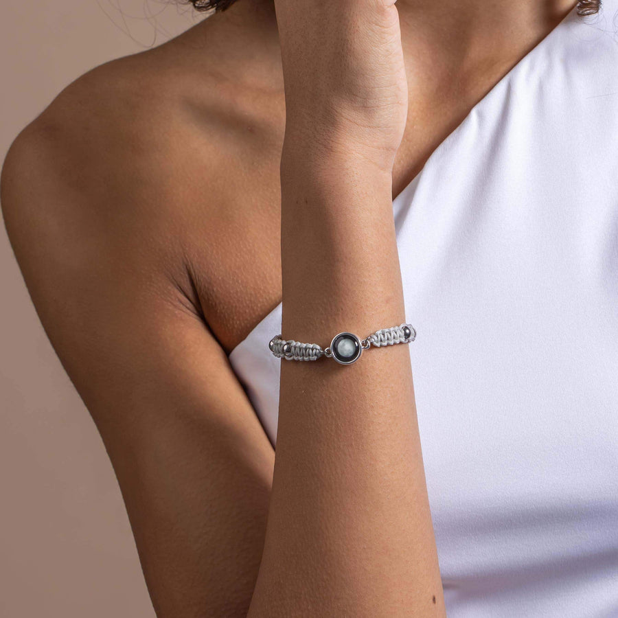 Woman wearing silver plated adjustable moon phase bracelet in sky gray 